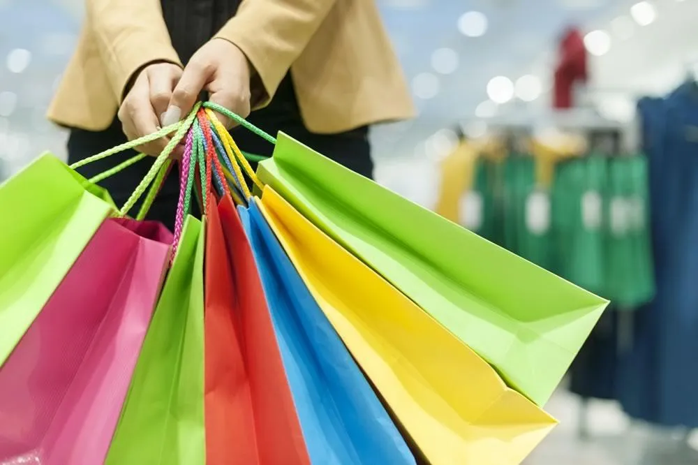 Mulher segurando sacolas coloridas de compras
