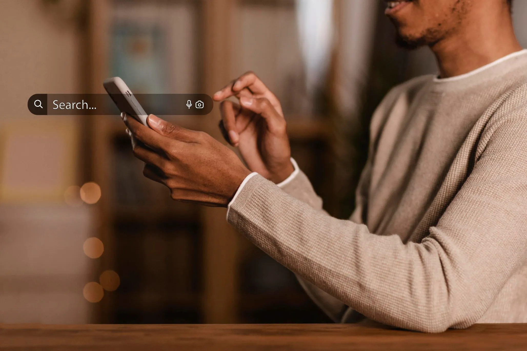 Homem negro mexendo no celular com aba de busca do lado