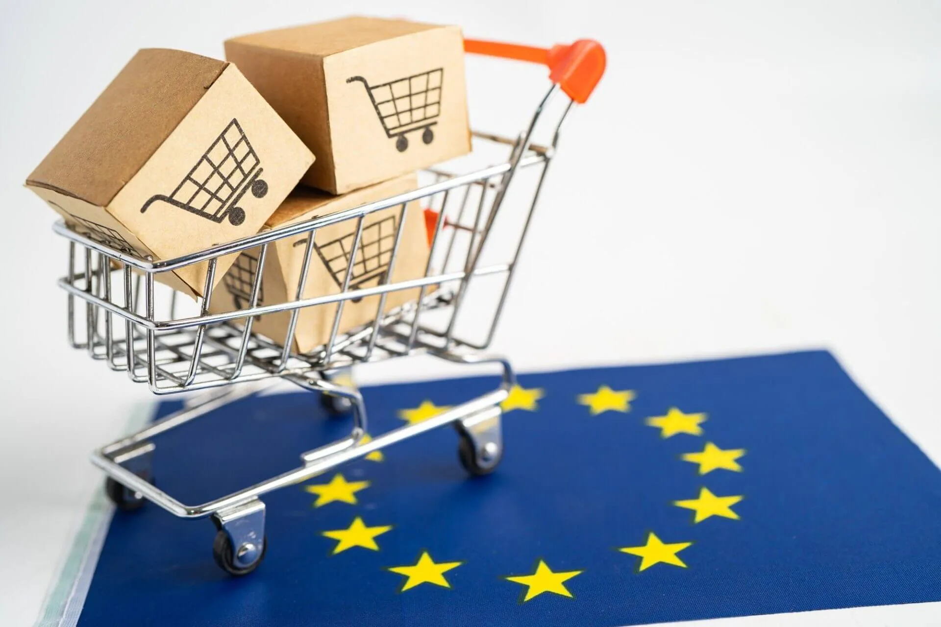 Miniatura de carrinho de supermercado sobre a bandeira da união europeia