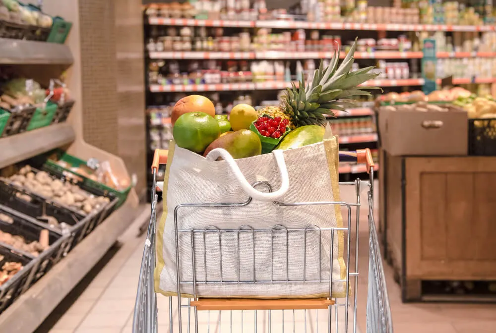 Carrinho de supermercado com sacola de compras com frutas 