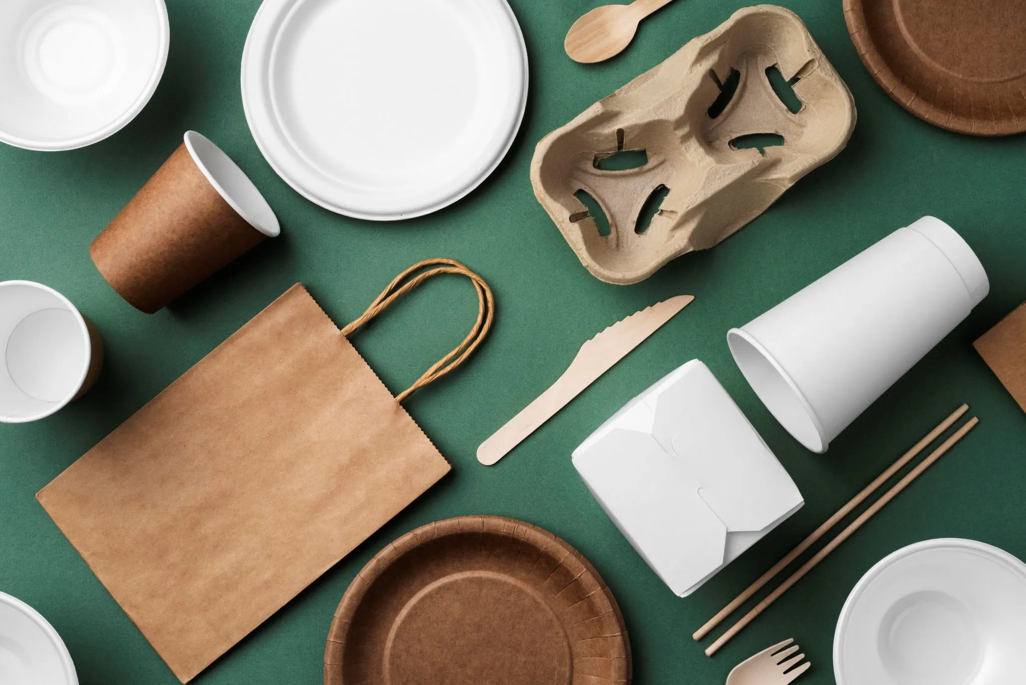 Fundo verde com sacolas, copos, talheres e pratos biodegradáveis