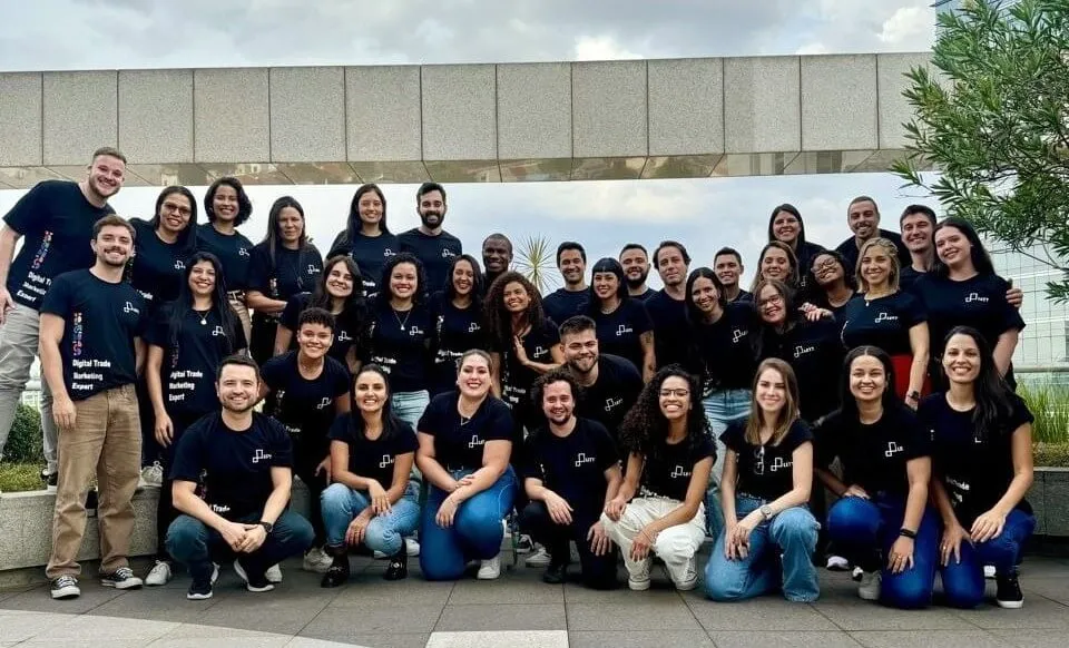 Equipe da empresa Lett posando para foto em frente ao escritório da empresa