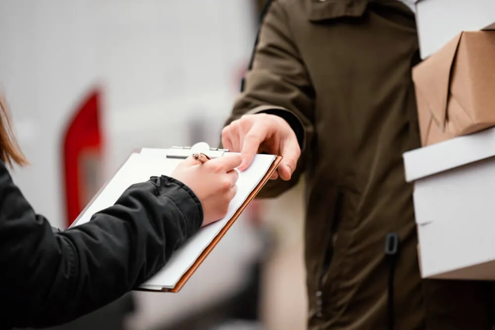 Pessoa assinando documento para receber entregas em casa