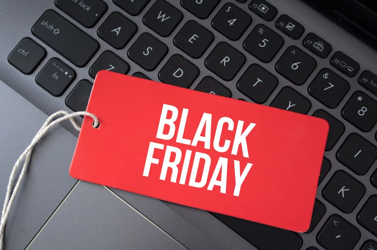 Etiqueta vermelha em cima de computador com Black Friday escrito em branco