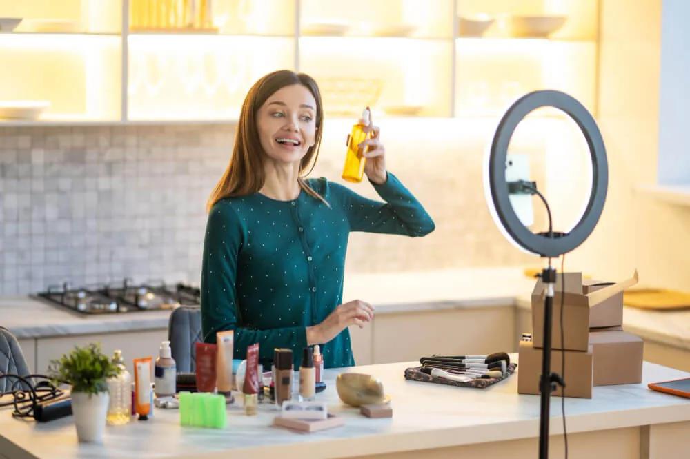 Mulher criadora de conteúdos mostrando produtos de beleza em frente a telefone 