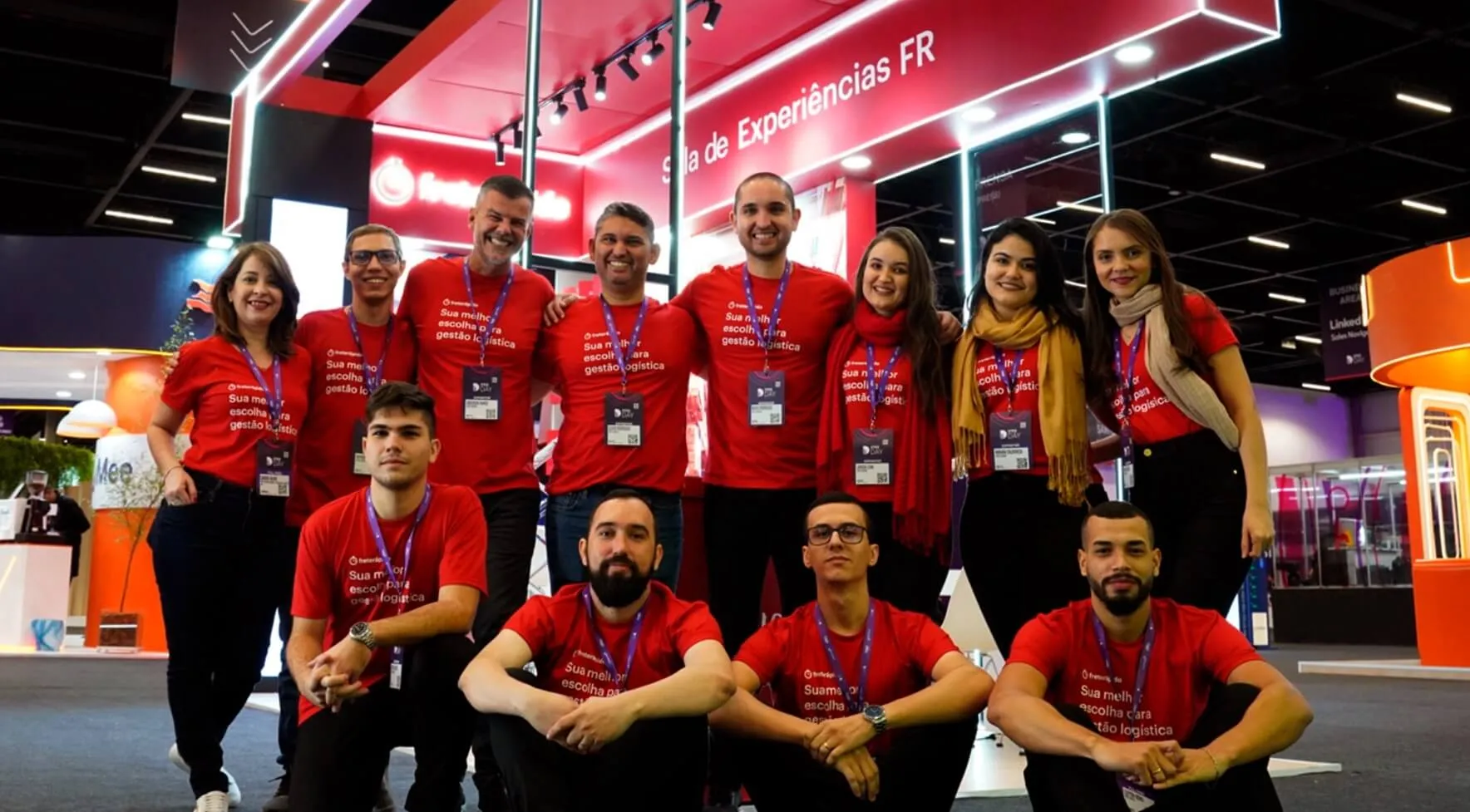 Equipe da Frete Rápido reunida em frente a stand de evento