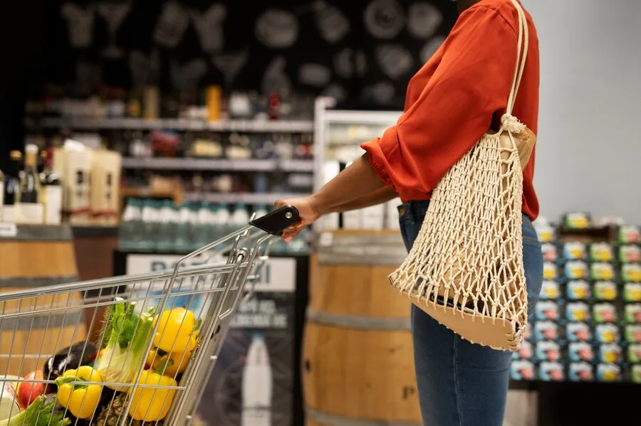 Mulher empurrando carrinho de compras de supermercado