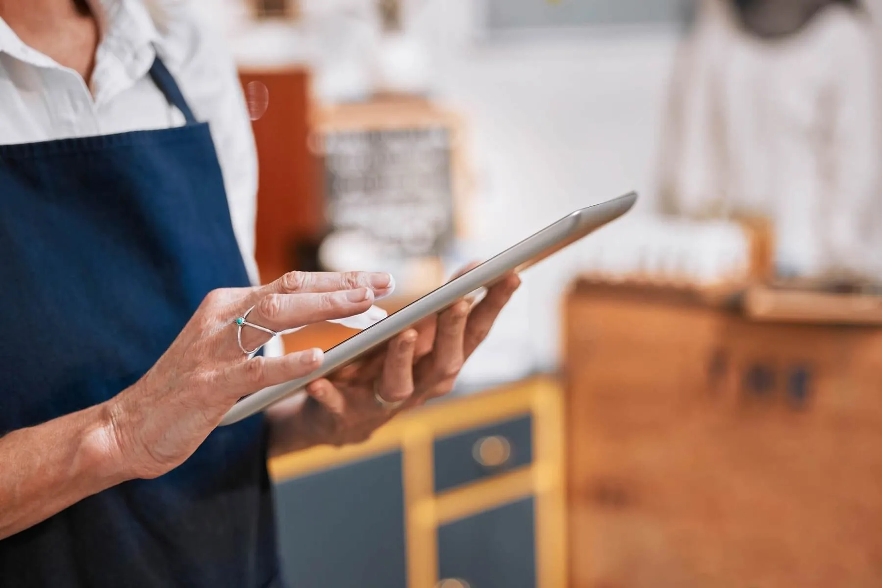 Mulher mexendo em tablet em loja de roupas