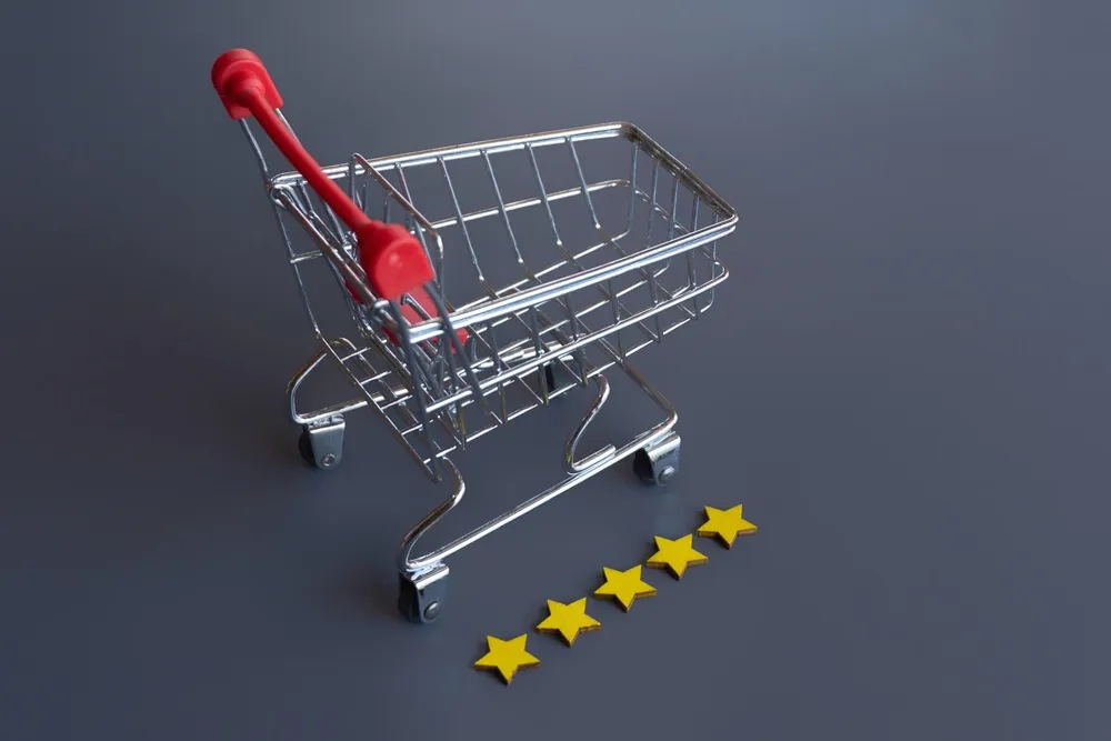 Carrinho de compras vazio em fundo cinza escuro ao lado de cinco estrelas amarelas.