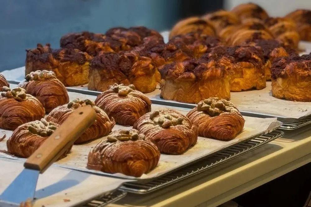 Entre fornos e algoritmos: o case francês que une confeitaria e inteligência artificial 2 Pães e croissants dispostos em balcão.