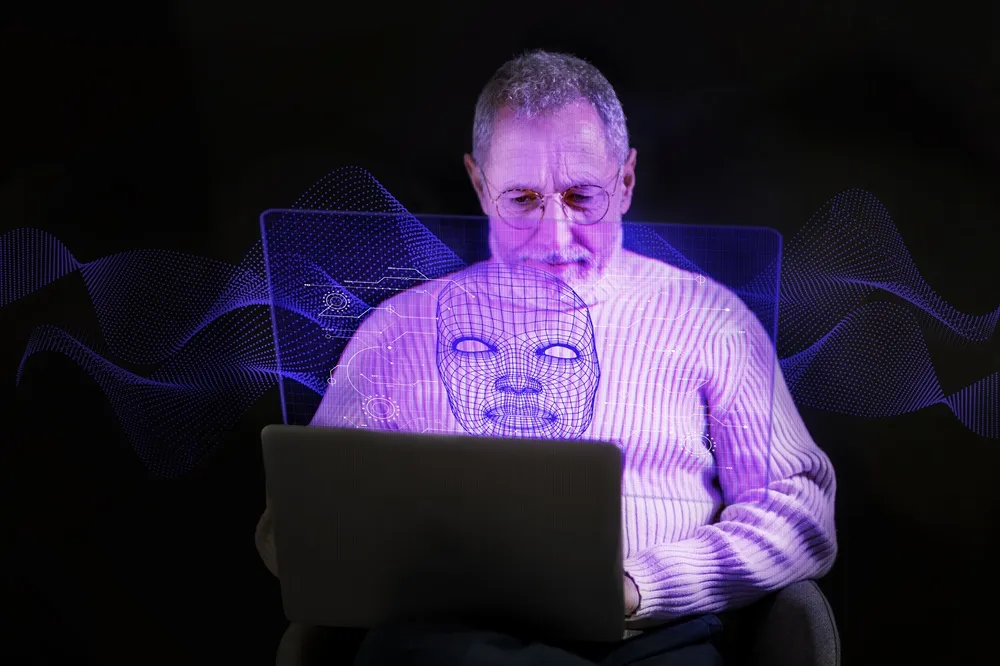 Homem usa laptop com projeções digitais em roxo, como um rosto 3D e gráficos.