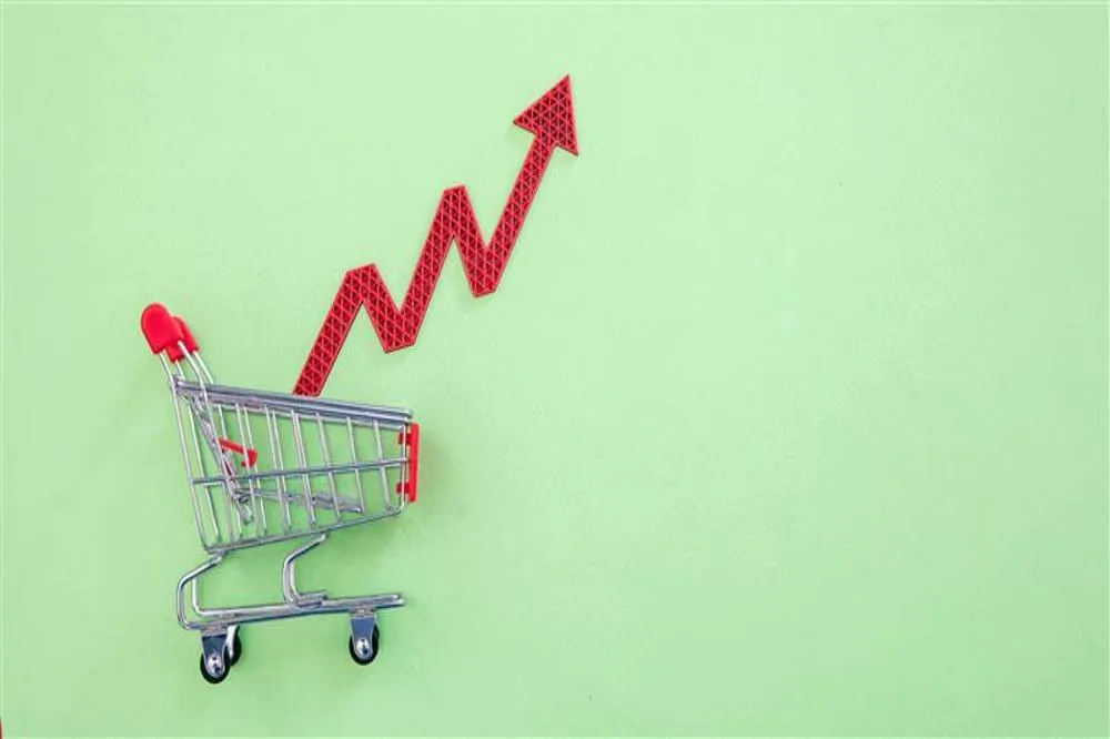 Carrinho de compras empurrando uma seta vermelha em zigue-zague apontando para cima.