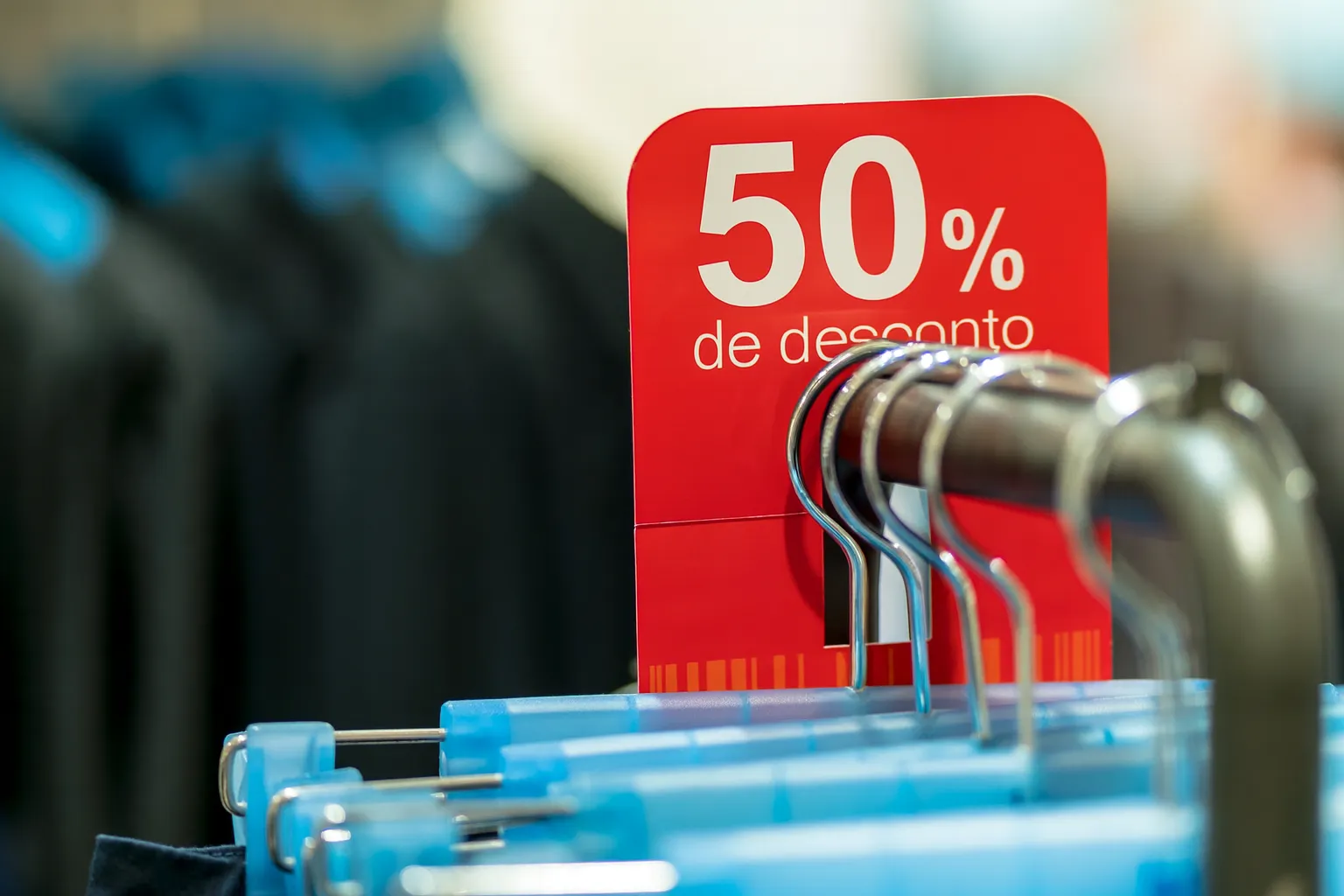 anúncio de 50% de desconto exibido sobre as roupas
