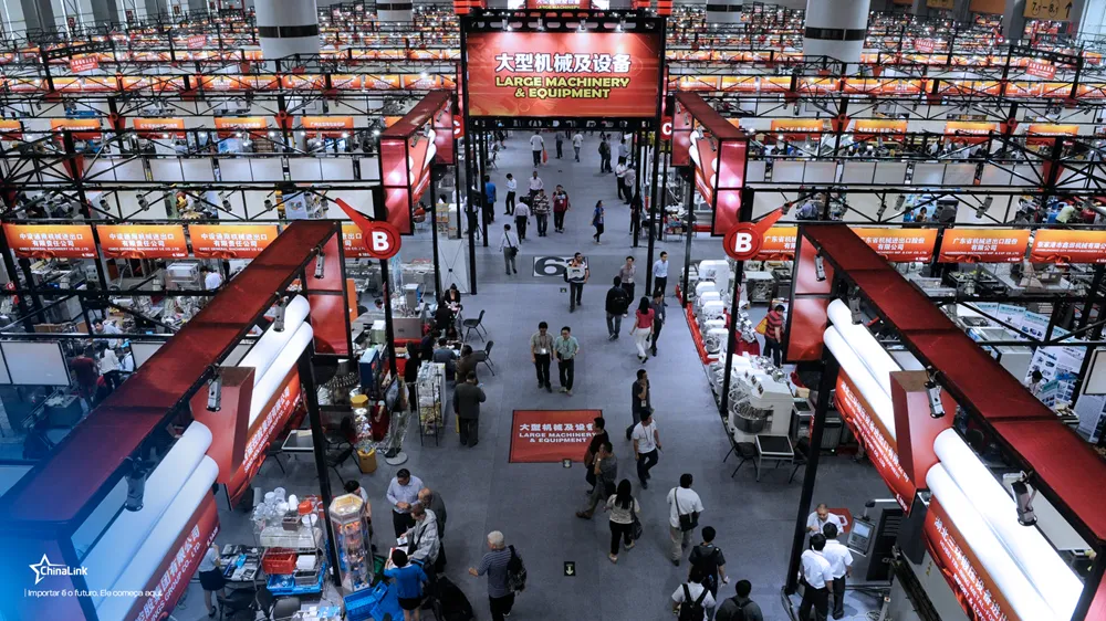 Vista aérea de pavilhão com estandes de máquinas industriais e letreiro "Large Machinery & Equipment" centralizado.